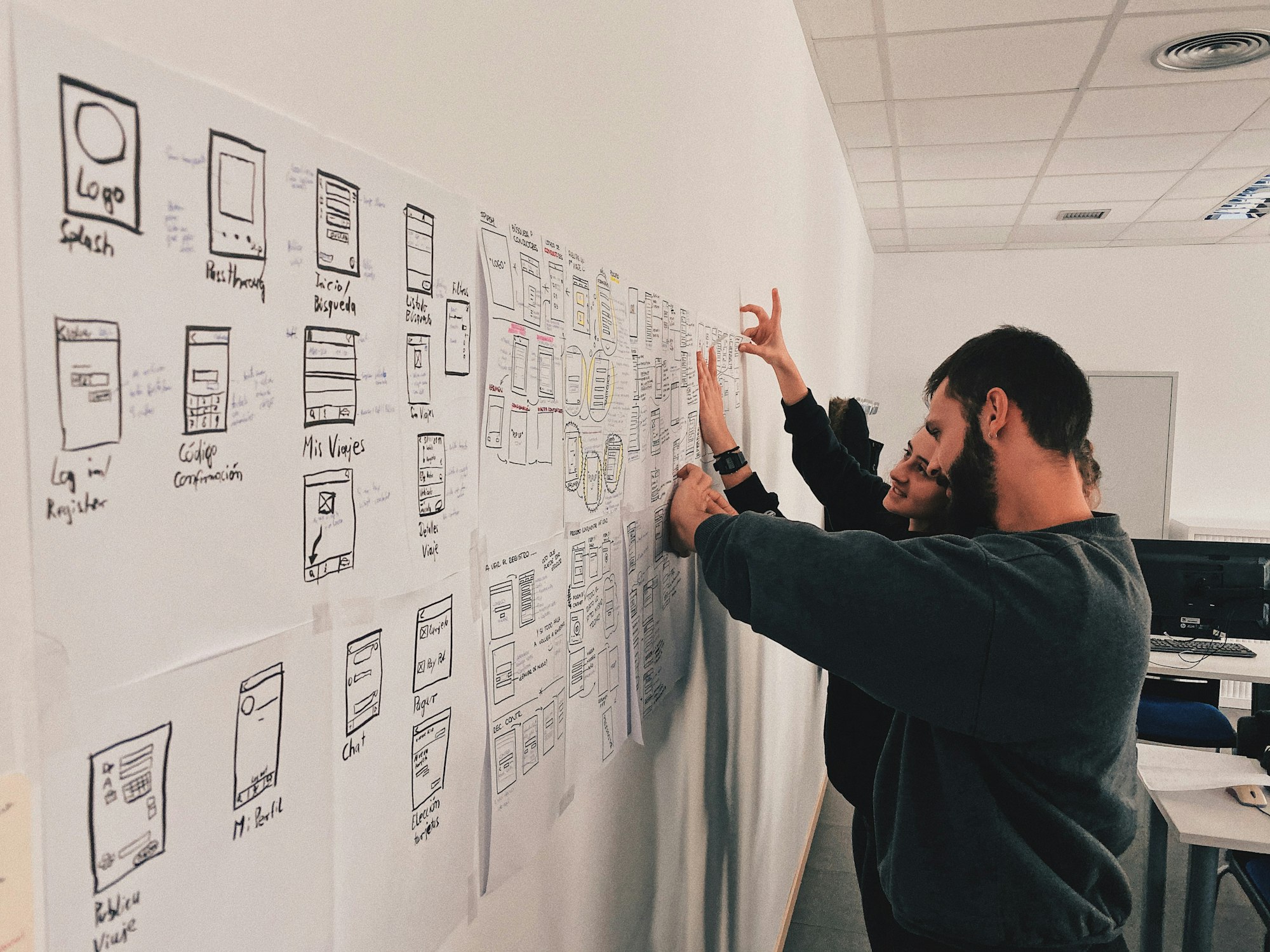 A wall of design artefacts and user journey maps